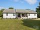 Charming home exterior showcasing a well-maintained lawn, inviting front porch with swing, and manicured landscaping at 130 Johnson Dairy Rd, Rockwell, NC 28138