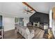 Cozy living room features hardwood floors, wood ceiling beams, a dark accent wall and comfortable seating at 130 Johnson Dairy Rd, Rockwell, NC 28138