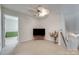 This bonus room is staged with a television, flowers, neutral carpet, and has an open doorway to another room at 1532 Andora Dr, Rock Hill, SC 29732