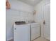 This laundry room features a washer, dryer, wire shelf, tile flooring, and a white door at 1532 Andora Dr, Rock Hill, SC 29732