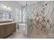 Spa-like bathroom featuring a soaking tub, walk-in shower, marble accent wall, and a stylish vanity with elegant fixtures at 15913 Trenton Place Rd, Huntersville, NC 28078