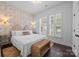 Charming bedroom with wallpaper accent wall, and shuttered windows that allow ample natural light to fill the space at 15913 Trenton Place Rd, Huntersville, NC 28078