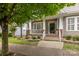 Inviting front porch with white columns, brick accents, beautiful landscaping and a decorative front door at 15913 Trenton Place Rd, Huntersville, NC 28078