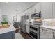 Stainless steel appliances, gas range, microwave, and white cabinets in this home's modern kitchen at 15913 Trenton Place Rd, Huntersville, NC 28078