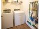 A well-lit laundry room features a washer, dryer, and storage rack with cleaning supplies at 1600 Gaston Mountain Dr, Dallas, NC 28034
