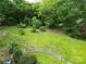 Spacious backyard with lush green grass, mature trees, and charming white picket fence outlining the property at 206 Rose Ter, Wadesboro, NC 28170