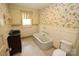 Quaint bathroom featuring a classic tub, floral wallpaper, and unique fixtures at 206 Rose Ter, Wadesboro, NC 28170