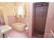 Pink-tiled bathroom with vintage fixtures, tub, and shower at 206 Rose Ter, Wadesboro, NC 28170