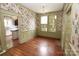 Dining room featuring classic floral wallpaper, windows with green shutters, and hardwood flooring at 206 Rose Ter, Wadesboro, NC 28170