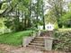 Stone steps leading to the front yard, enveloped by verdant greenery and mature trees at 206 Rose Ter, Wadesboro, NC 28170