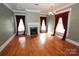 Inviting living room with a fireplace, hardwood floors, and large windows with drapes at 206 Rose Ter, Wadesboro, NC 28170
