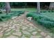 Stone path through a backyard featuring landscaping and mature trees, offering a tranquil outdoor setting at 211 Southfork Dr, Belmont, NC 28012