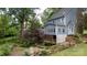 Picturesque backyard featuring a cozy porch, lush greenery, and a charming wooden fence at 211 Southfork Dr, Belmont, NC 28012