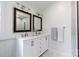 Bathroom featuring dual sinks with modern fixtures, framed mirrors, and towel bars at 211 Southfork Dr, Belmont, NC 28012