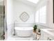 This bathroom features a soaking tub under a skylight with white marble flooring and white marble walls at 211 Southfork Dr, Belmont, NC 28012