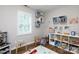 Bright playroom featuring hardwood floors, stylish white shelving, and a window bringing in natural light at 211 Southfork Dr, Belmont, NC 28012