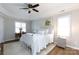 Bright bedroom features a tray ceiling, ceiling fan, and a quaint writing desk illuminated by natural light at 211 Southfork Dr, Belmont, NC 28012