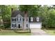 Charming two-story home with blue siding, black shutters, and a well-manicured lawn, offering classic curb appeal at 211 Southfork Dr, Belmont, NC 28012