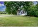 Two-story home with mature trees, attached two car garage, and large lawn at 211 Southfork Dr, Belmont, NC 28012