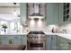Modern kitchen with stainless steel appliances, stone backsplash, quartz countertops, and sage cabinets at 211 Southfork Dr, Belmont, NC 28012