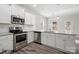 Well-lit kitchen featuring stainless steel appliances, white cabinets, and granite countertops at 215 Lake George Dr, Shelby, NC 28152