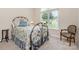 Cozy bedroom with a wrought iron bed frame, floral bedding, and bright natural light from the large window at 2333 Wednesbury Ct, Kannapolis, NC 28083