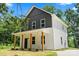 Charming two-story home boasts a welcoming front porch with wood columns and a modern two-tone facade at 25 Mickley Ave, Bessemer City, NC 28016