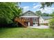 Home's exterior with wooden deck and staircase leading to a lush, green backyard at 255 South Academy St, Mooresville, NC 28115