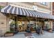 Charming cafe exterior featuring striped awning, large windows, and outdoor seating at 255 South Academy St, Mooresville, NC 28115