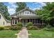 Charming brick home featuring a beautifully landscaped front yard and inviting screened-in porch at 255 South Academy St, Mooresville, NC 28115