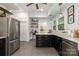 Open kitchen with stainless steel appliances, floating shelves and black cabinets with gold hardware at 255 South Academy St, Mooresville, NC 28115