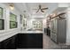 Bright kitchen with stainless steel appliances, floating shelves and black cabinets with gold hardware at 255 South Academy St, Mooresville, NC 28115