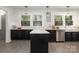 Renovated kitchen showcasing stainless steel appliances, apron sink and black cabinets with gold hardware at 255 South Academy St, Mooresville, NC 28115