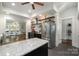 Gourmet kitchen featuring stainless steel appliances, floating shelves and black cabinets with gold hardware at 255 South Academy St, Mooresville, NC 28115