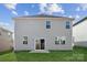 Backyard featuring a gray two-story house with windows and a sliding glass door, on a green lawn at 2592 Blue Sky Meadows Dr, Monroe, NC 28110