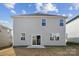 Backyard featuring a gray two-story house with windows and a sliding glass door, on a brown lawn at 2592 Blue Sky Meadows Dr, Monroe, NC 28110