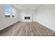 Bright living room with fireplace, large windows, wood-look flooring, and modern finishes at 2592 Blue Sky Meadows Dr, Monroe, NC 28110