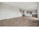 Open-concept living space with wood-look flooring, connecting the living room, kitchen, and staircase at 2592 Blue Sky Meadows Dr, Monroe, NC 28110