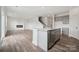 Open concept living space with modern kitchen island, fireplace, wood-look floors, and lots of natural light at 2592 Blue Sky Meadows Dr, Monroe, NC 28110