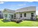 Backyard showcasing the sunroom, stone fire pit, lush green lawn, plants, and trees at 2658 Manor Stone Way, Indian Trail, NC 28079