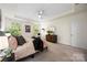 Bright bedroom features neutral tones, stylish furnishings, a ceiling fan, and natural light at 2658 Manor Stone Way, Indian Trail, NC 28079