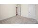 Bright bedroom featuring neutral carpeting, trim, and a view into the adjacent hallway at 2658 Manor Stone Way, Indian Trail, NC 28079