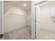 Walk-in closet with shelving in neutral tones leads to laundry room at 2658 Manor Stone Way, Indian Trail, NC 28079