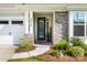 Inviting front entrance with stone accents, lush landscaping, and a decorative glass door at 2658 Manor Stone Way, Indian Trail, NC 28079