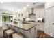 Modern kitchen featuring large island, stainless vent hood, and view to the outside at 2658 Manor Stone Way, Indian Trail, NC 28079