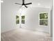 Bright bedroom has plush carpet, three windows providing natural light, a ceiling fan and fresh white walls at 27 Mickley Ave, Bessemer City, NC 28016