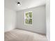 Bright bedroom with plush carpet, large window providing natural light, and fresh white walls at 27 Mickley Ave, Bessemer City, NC 28016