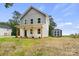 Charming two-story home featuring white siding, gray accents, a covered porch, and a storage shed in the backyard at 27 Mickley Ave, Bessemer City, NC 28016