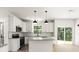 Bright kitchen features white cabinets, stainless steel appliances, granite counters, and a center island at 27 Mickley Ave, Bessemer City, NC 28016