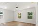 Spacious living room with light hardwood floors, white walls, modern lighting, and windows showcasing lush greenery outside at 27 Mickley Ave, Bessemer City, NC 28016